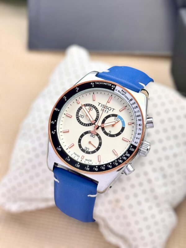 Tissot 1853 Chronograph Watch for Men – White Dial with Rose Gold Accents, Blue Leather Strap, and Tachymeter Bezel